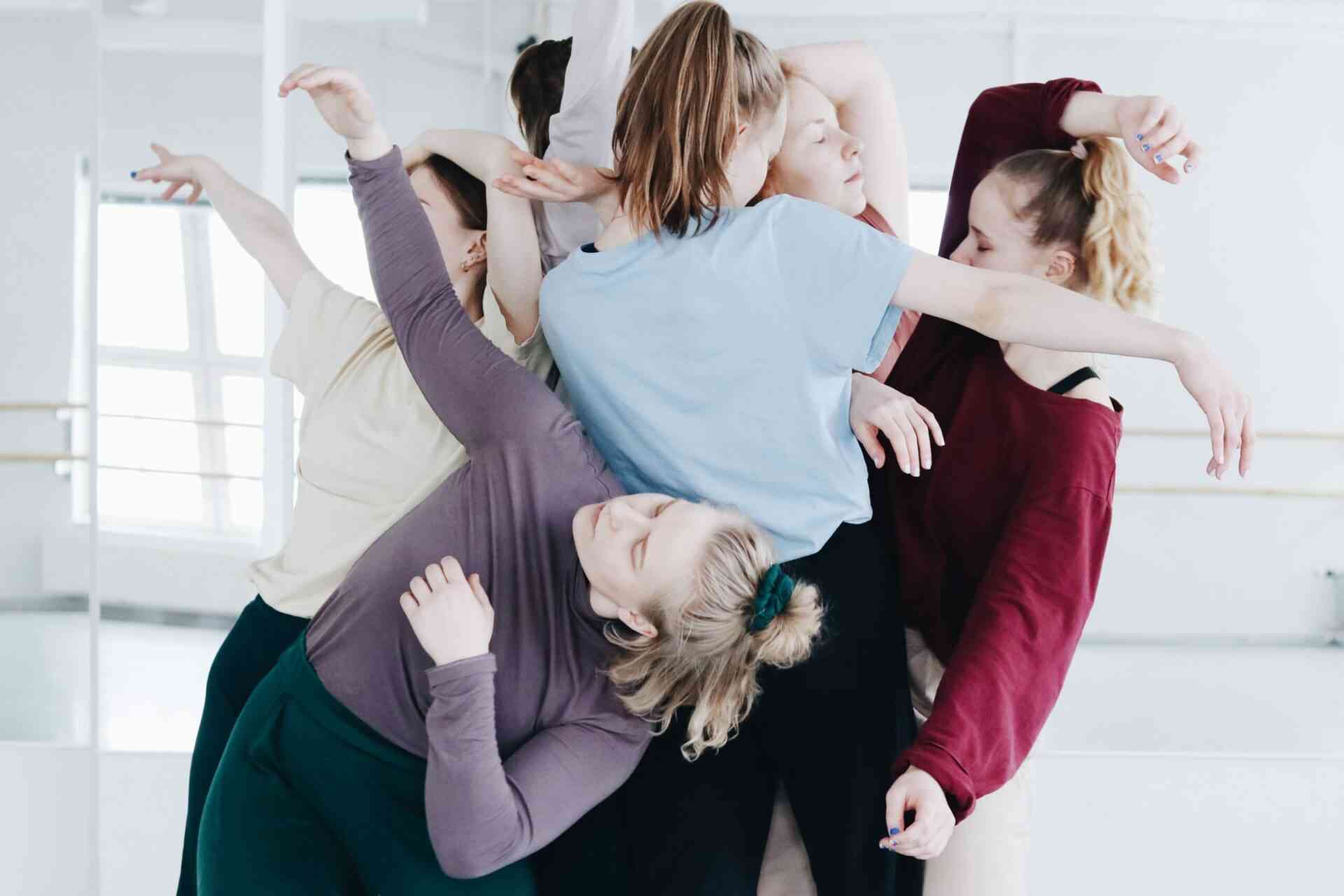 A group of dancers posing in a bright room